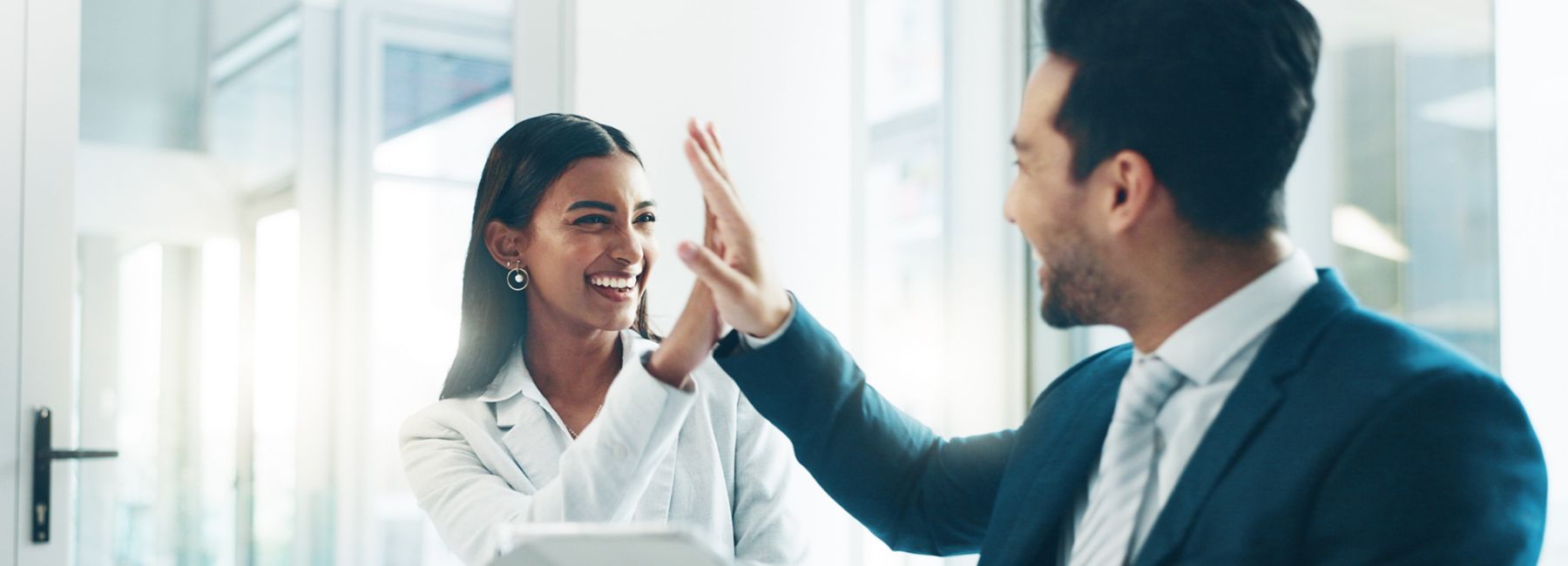 Man and woman giving each other High 5's in office, Modern Workplace| DXC Technology Insights